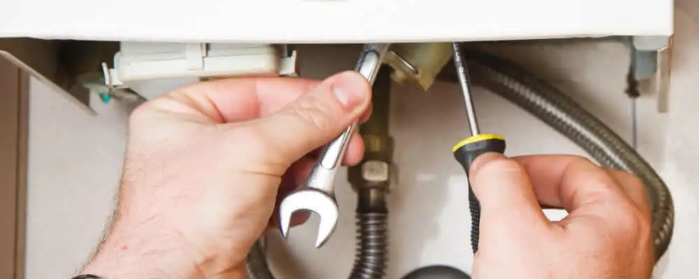 Boiler repair technician tightening pipe fittings and connections in Raleigh, NC