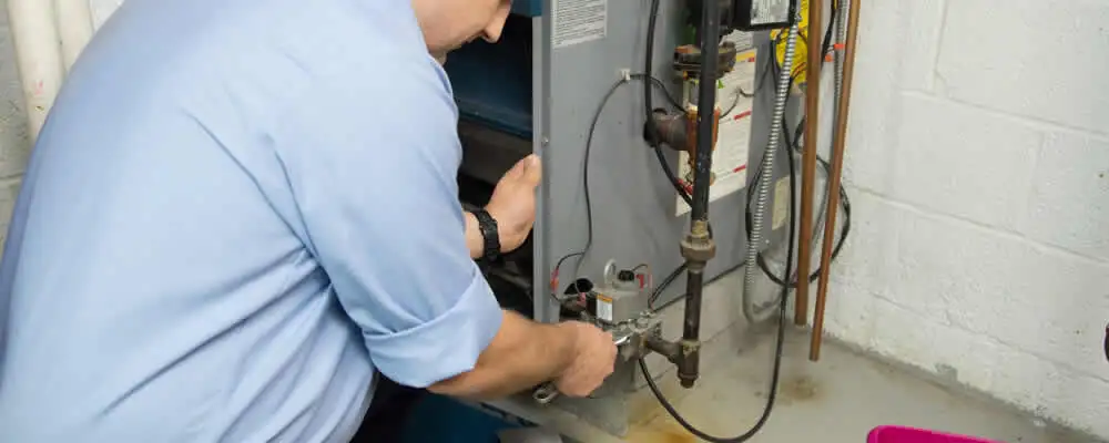 Furnace repair technician inspecting and servicing a home heating system in Raleigh, NC