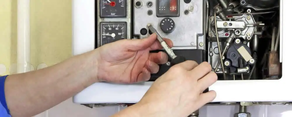 Heating repair technician adjusting boiler controls and components in Raleigh, NC