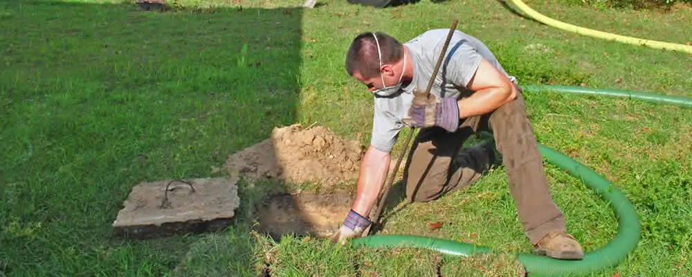 Septic pumping technician servicing a residential septic tank in Raleigh, NC