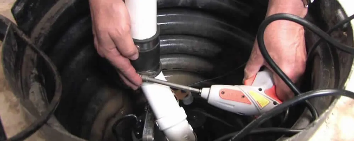 Sump pump installation technician connecting PVC discharge piping in Raleigh, NC